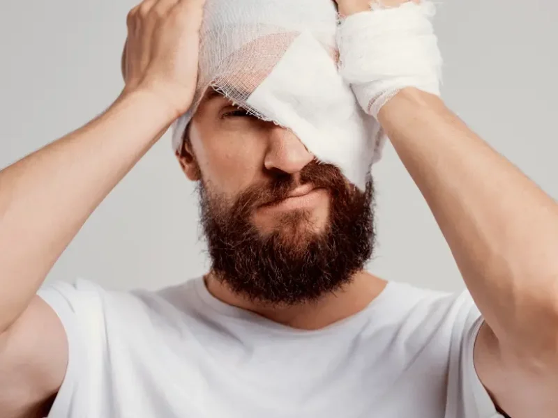 Patient showing facial trauma bandage around head and eye